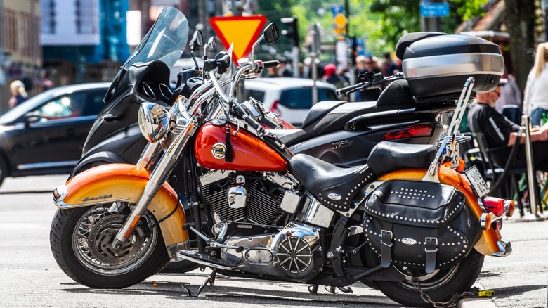 An orange Harley-Davidson Softail parked on the street.