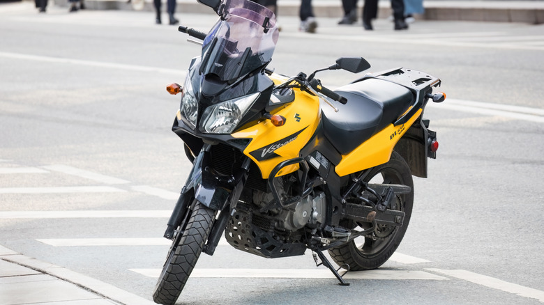 A black and yellow Suzuki V-Strom 650 parked on a city street