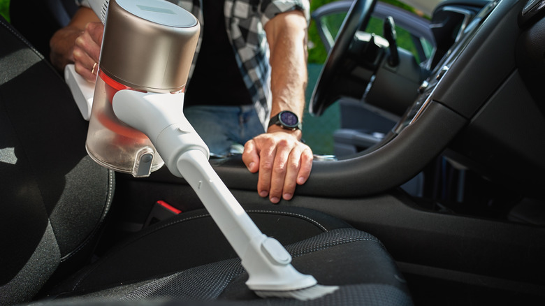 Person vacuuming car seat