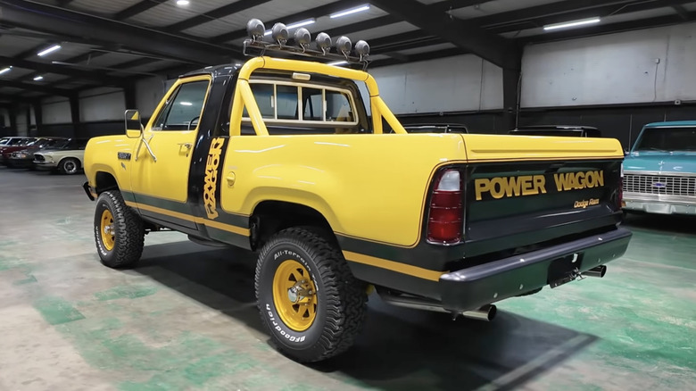 A bright yellow 1980 Dodge "Macho" Power Wagon parked in a garage.