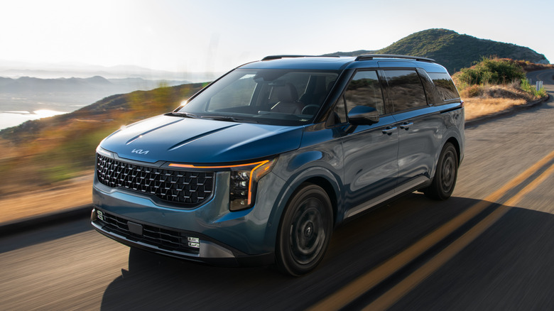 Front quarter view of Kia Carnival driving down road