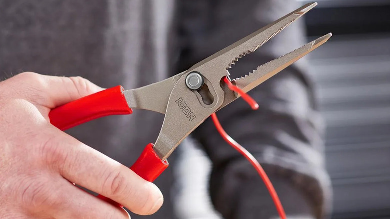 Icon Long-Nose pliers being used to strip wires, held up facing the camera