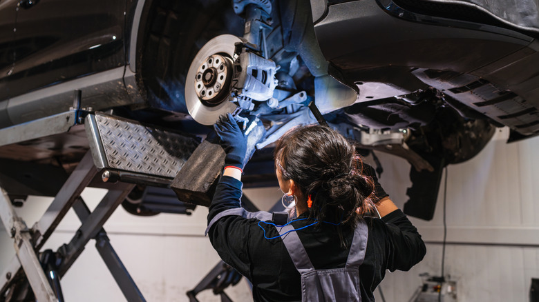 A mechanic working on a car's brakes.