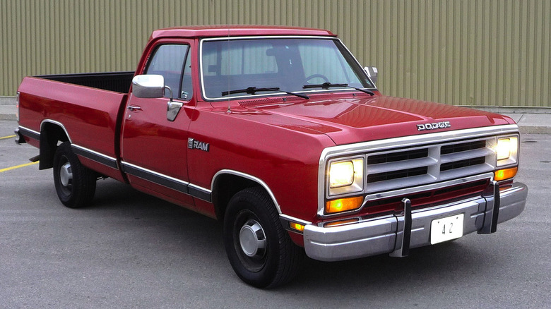 A red Dodge Ram in a parking lot by a building