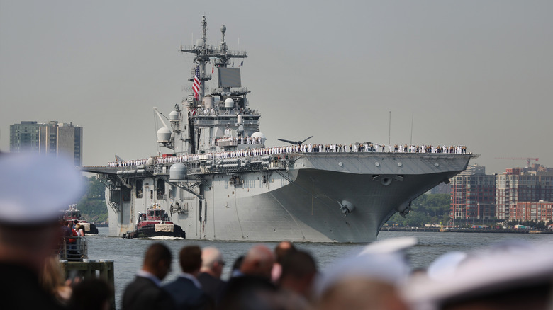 The USS Wasp, an amphibious assault ship, painted in grey passing through a channel.