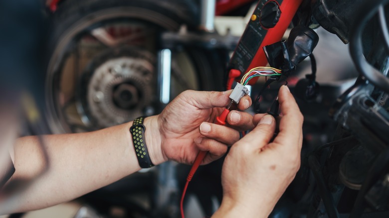 Mechanic repairing motorcycle electronics