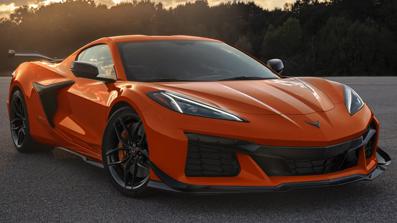 An orange Chevy Corvette Z06 in a parking lot at dusk