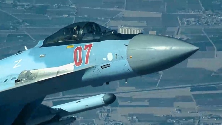 Close-up of a Su-35 fighter's nose and cockpit in flight.