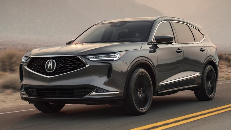 Acura MDX driving down a road