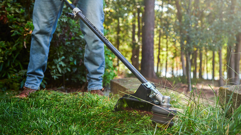 person using Ryobi string trimmer