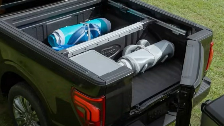 Black Ford F-150 pickup with Pro Access tailgate open demonstrating  how it avoids hitting the trailer