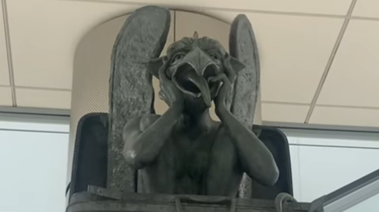 bird-faced gargoyle statue in a suitcase