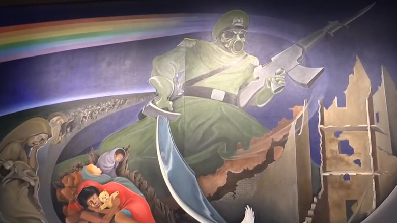 a mural of a soldier with a gun and sword over a war torn area