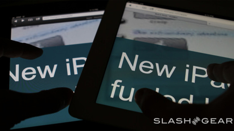 A pair of iPads with darkened hands navigating them