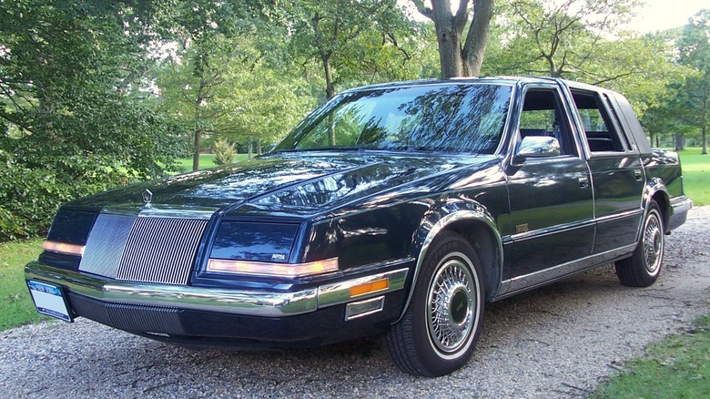 Black Chrysler Imperial on a forested gravel road