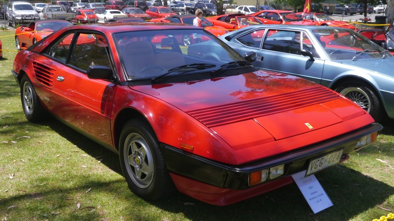 Red Ferrari Mondial 8 parked on grass at a car show