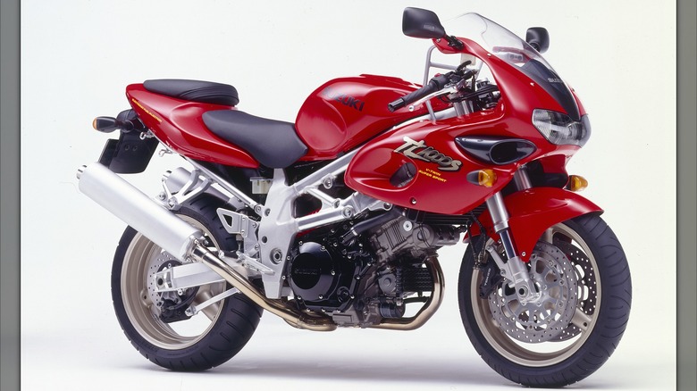 A red Suzuki TL1000S sport bike with a sculpted fairing and exposed V-twin engine on a studio background.