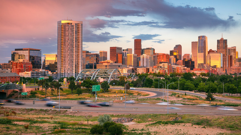 Skyline of Denver, CO with cars on the highway