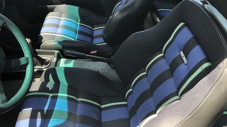 The blue, black and green patterned cloth seats on a Recaro
