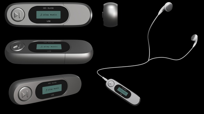 Four USB flash drive MP3 players with one connected to wired earphones