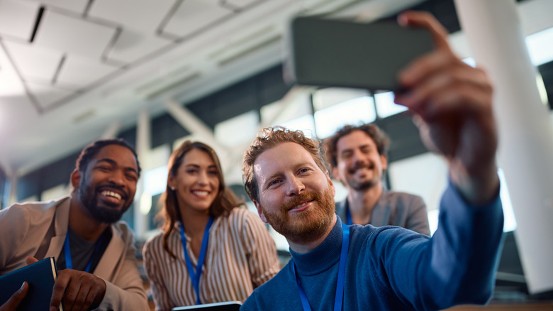Group of people taking a selfie in public.