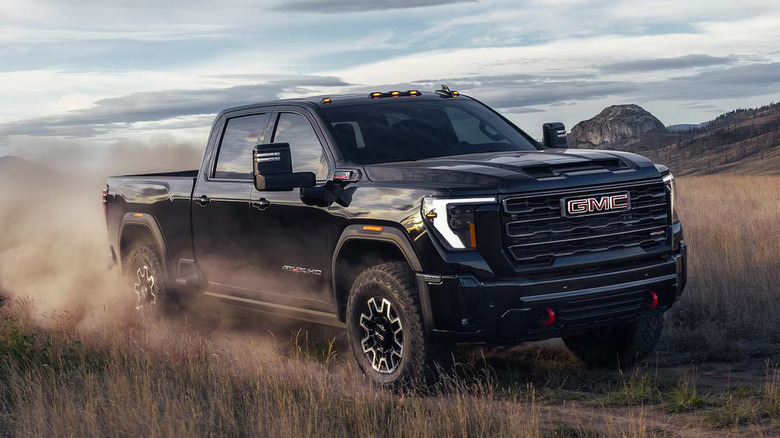 Black GMC Sierra HD driving on a dirt road