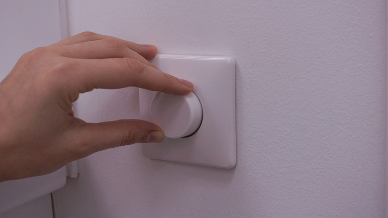 hand turning a dimmer switch