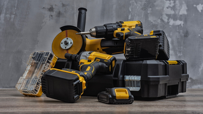 A pile of various power tools and batteries