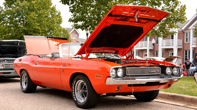 An orange 1970 Dodge Challenger R/T convertible with its hood and trunk open.