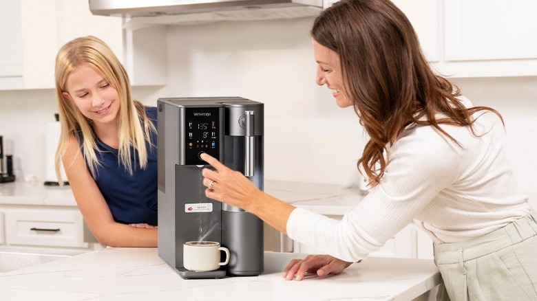 Woman and child using Waterdrop Filter RO system A2 to make cup of coffee