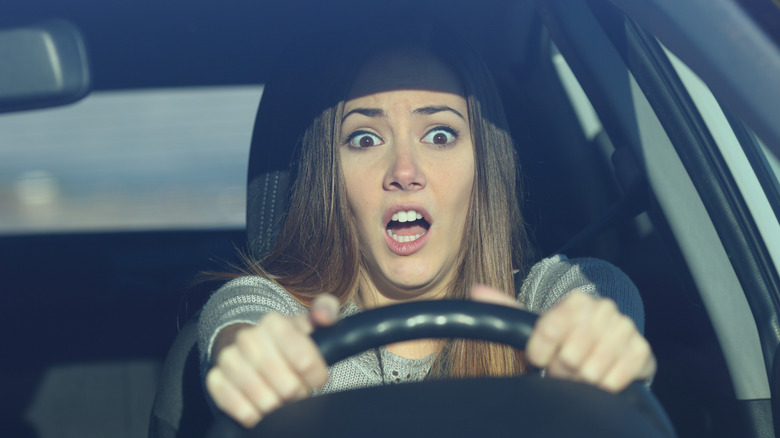 Front view of driver scared because steering wheel is shaking