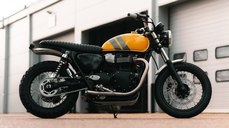 A retro motorcycle parked in front of a garage