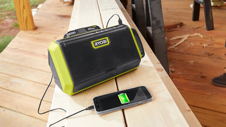 The Ryobi One+ Speaker charging a phone, in a building under construction