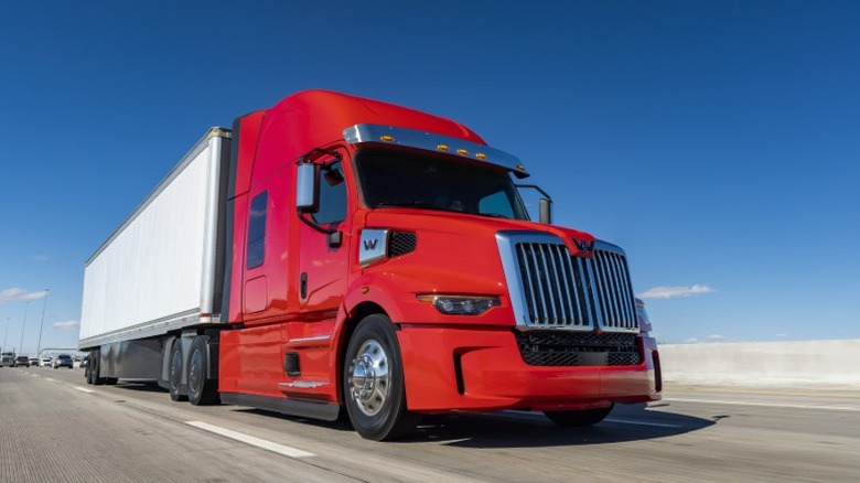 A red Western Star 57X driving on a freeway