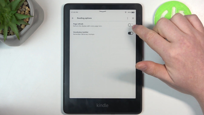 Person changing Kindle settings on table