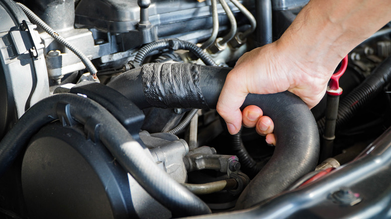 Person working on old radiator hose