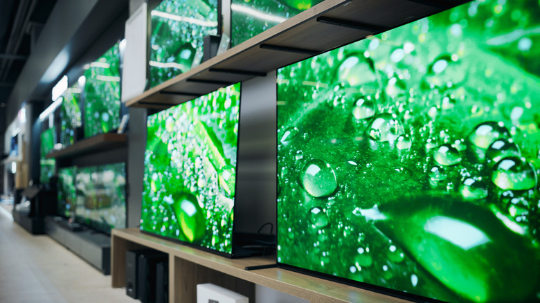 An assortment of 4K TVs on display in a department store.