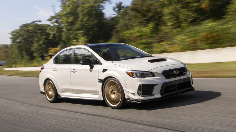 A white Subaru Impreza WRX STI S209 on the move on a race track, front 3/4 view