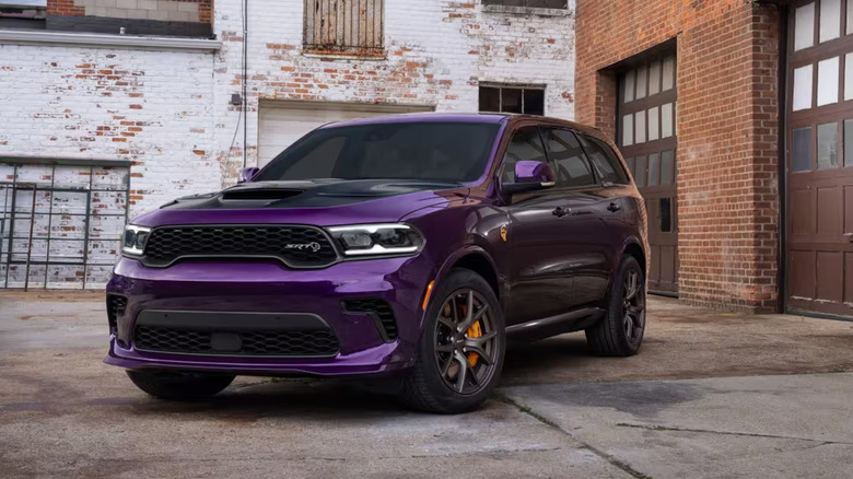 A purple Dodge Durango parked near brick buildings