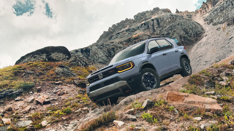 A blue Honda Passport on a rocky trail