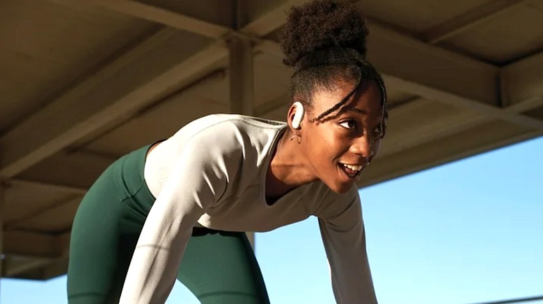 Person wearing JBL Endurance Peak 3 ear buds while she works out