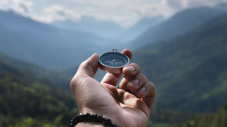 hand holding magnetic compass