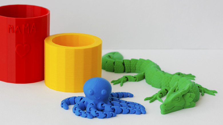 3D printed toys, including a blue octopus and a green alligator