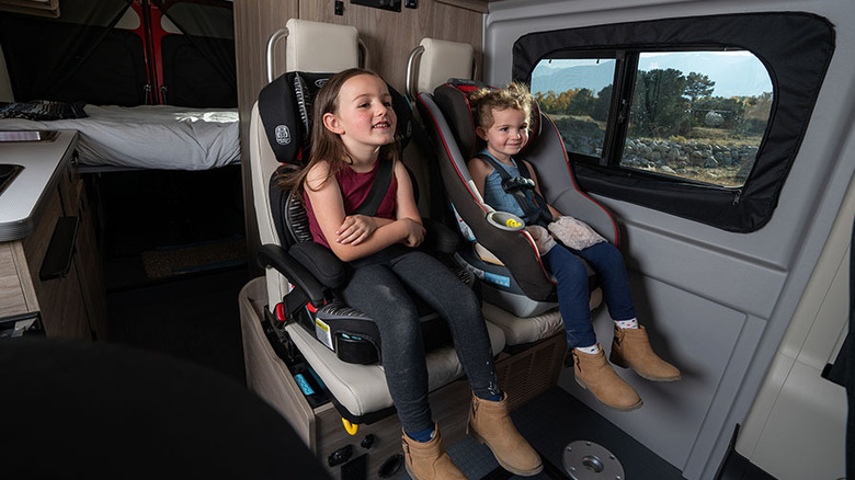 Two children in car seats inside an RV