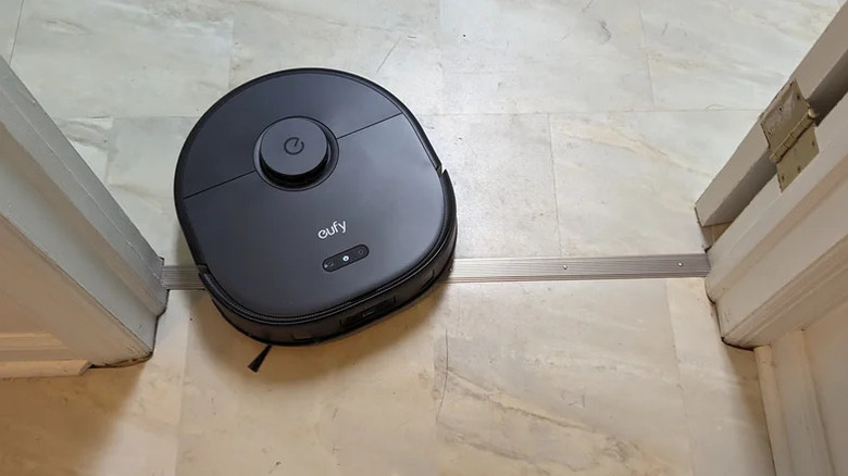 The Eufy X10 Pro Omni driving over a flooring transition strip