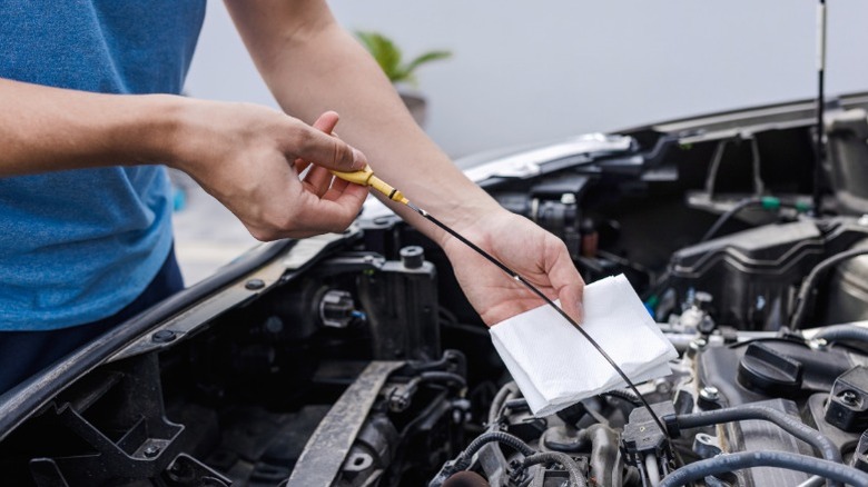 A person checking a car's oil