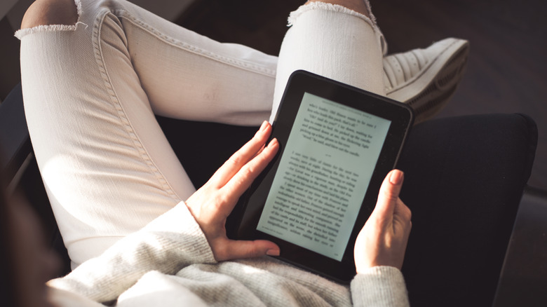 A person relaxing as they read an e-book