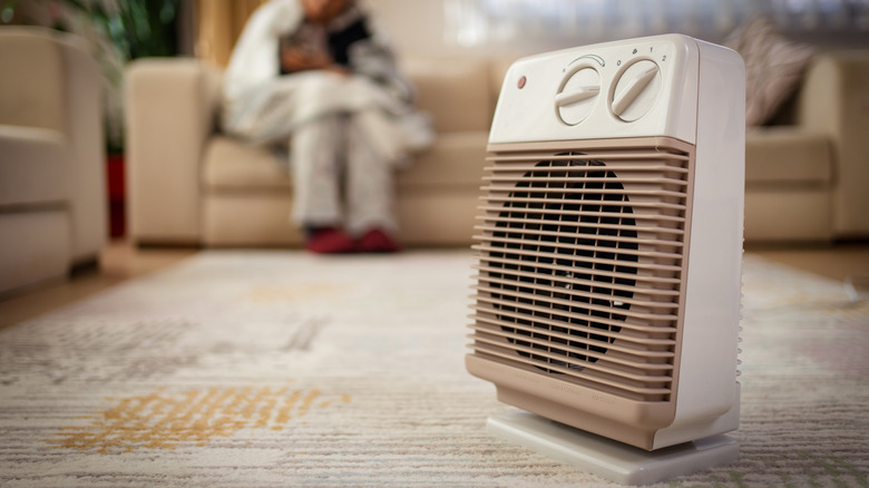 Close-up of space heater with a living room in the background