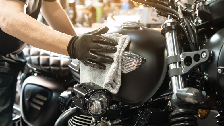 A man cleaning the fuel tank of a motorcycle