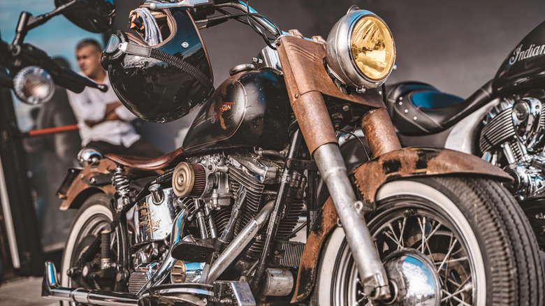 A rusty Harley-Davidson motorcycle on display at a show